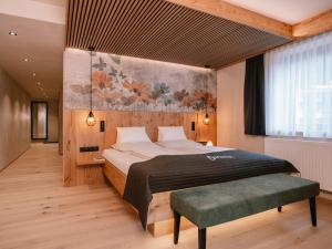a bedroom with a large bed with a large painting on the wall at Familienresort Buchau in Maurach +140 photos