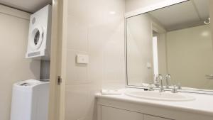 a white bathroom with a sink and a mirror at Boambee Bay Resort in Bonville