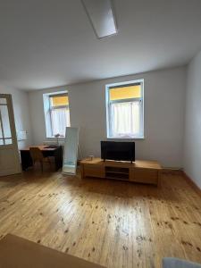 a living room with a tv on a table and two windows at Centrum Brezno in Brezno