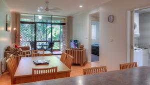 a kitchen and living room with a table and chairs at Boambee Bay Resort in Bonville