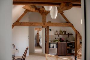 a kitchen with wooden beams in a room at Coureilles Appartements et Suites in La Rochelle