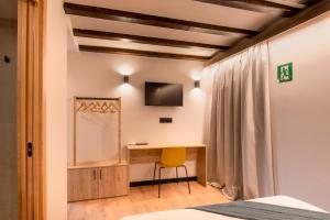 a bedroom with a desk and a tv on the wall at Hotel Casa Juan in Ayegui