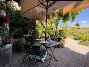 a table and chair under an umbrella in a garden at Il giardino di Nara in San Gimignano +13 photos