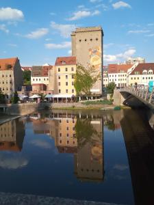 a bridge over a river in a city with buildings at Zum Senckenberg by Satischni in Görlitz