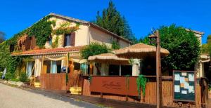 a house with a fence and an umbrella at Auberge des Salelles - Zarathoustra in Saint-Maurice-dʼIbie