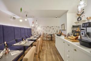 a dining room with tables and blue booths at Hôtel La Parizienne - Proche Montparnasse in Paris +23 photos