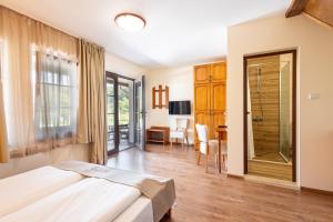 a bedroom with a bed and a desk and a table at Bashtinata stryaha Guest rooms and Natural pool in Beli Osŭm