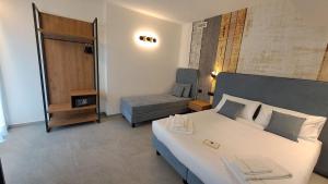 a bedroom with a large white bed and a chair at MOUNTAIN SUITE Hotel Apartment in Tirano