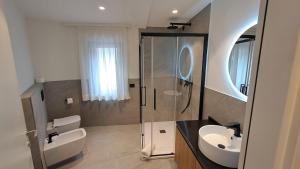a bathroom with a shower and a sink and a toilet at MOUNTAIN SUITE Hotel Apartment in Tirano