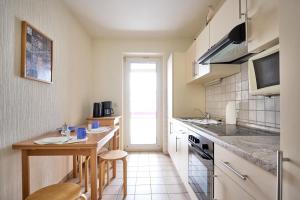 a kitchen with a table and some chairs in it at Haus Düne, Ferienwohnung 21 in Cuxhaven