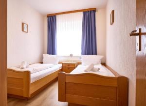 two beds in a room with a window at Haus Düne, Ferienwohnung 21 in Cuxhaven
