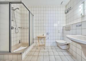 a bathroom with a shower and a toilet and a sink at Haus Düne, Ferienwohnung 21 in Cuxhaven +9 photos