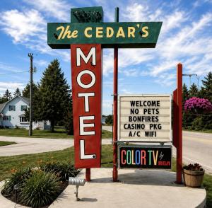 a sign for the cederarios motel next to a street at Cedars Motel in Saint Ignace