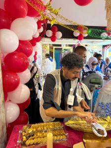 a man preparing food at a table with balloons at فندق الواحة الماسية نجمة 1 in Mecca