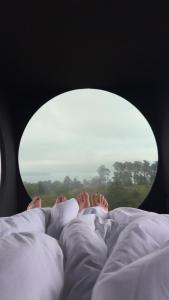 a person laying in bed with their feet sticking out at Birdbox Forland in Stord
