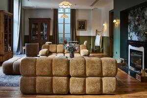 a living room with a large couch and a fireplace at Le Parc - Hôtel & Spa in Allevard +38 photos