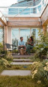 two people sitting on a bench in a garden at Zoku Paris in Paris +64 photos
