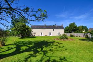 a large white house with a large yard at Gîte Lebasladin in Lison