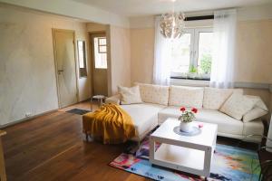 a living room with a white couch and a table at Apple Tree Garden House in Örebro