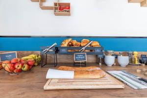 a table with a loaf of bread and a basket of fruit at Appart'City Classic Clermont Ferrand Centre in Clermont-Ferrand