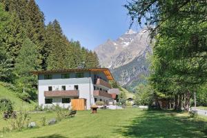 a building on a hill with a mountain in the background at Nature House Pflersch in Brennero