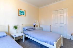 a bedroom with two beds and a door at Finest Retreats - Seabreeze, Rhos On Sea in Rhos-on-Sea