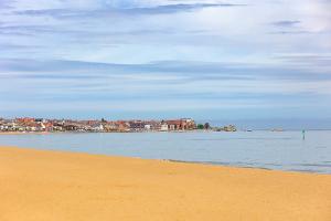 a view of a beach with a city in the background at Finest Retreats - Seabreeze, Rhos On Sea in Rhos-on-Sea
