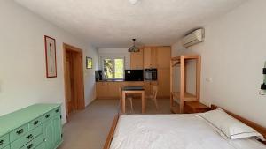 a bedroom with a bed and a kitchen with a table at Apartmaji Skalabon - Milena in Kanal