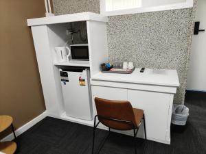 a small kitchen with a refrigerator and a microwave at Tintinara Hotel in Tintinara