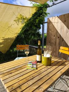 a wooden table with a bottle of wine and a glass at Apartment Linde Otzenhausen in Nonnweiler