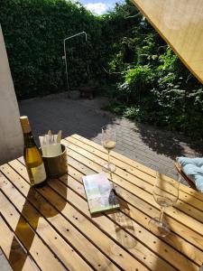 a bottle of wine and two glasses on a wooden table at Apartment Linde Otzenhausen in Nonnweiler