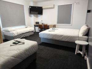 a hotel room with two beds and a flat screen tv at Tintinara Hotel in Tintinara