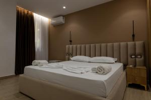 a bedroom with a bed with towels on it at Sea La Vie Hotel in Durrës