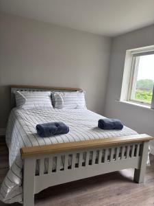 a bedroom with a bed with two blue towels on it at Moate View House in Ballymore Eustace
