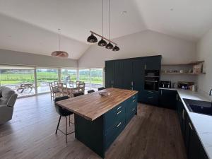a kitchen with green cabinets and a wooden table at Moate View House in Ballymore Eustace