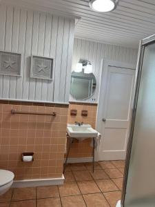 a bathroom with a sink and a mirror at 02-Sandbar Suite at The Castle Inn in Ocracoke