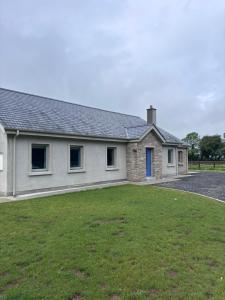 a white house with a yard in front of it at Moate View House in Ballymore Eustace