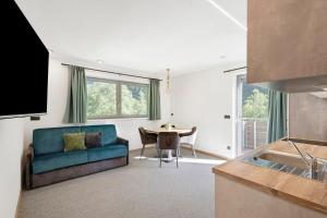 a living room with a blue couch and a table at Nature House Pflersch in Brennero
