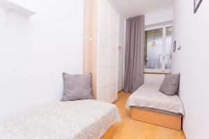 a bedroom with two beds and a window at Cozy Downtown Rooms in Warsaw