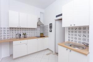 a kitchen with white cabinets and a sink at Cozy Downtown Rooms in Warsaw