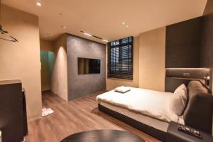 a bedroom with a bed and a flat screen tv at 貳宿文旅 in Tainan