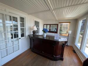 a room with a table with a vase of flowers on it at 06-Harbor Suite at The Castle Inn in Ocracoke