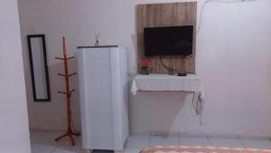 a white refrigerator in a room with a tv at Pousada Vela dos Ventos in Praia de Moitas