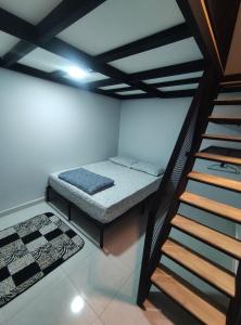 a small room with a bed and a staircase at Maileyna Homestay 3 in Alor Setar