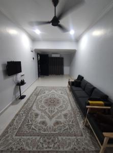 a living room with a couch and a rug at Maileyna Homestay 3 in Alor Setar