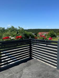 a black fence with flowers in the background at Apartment by Ela in Alpirsbach