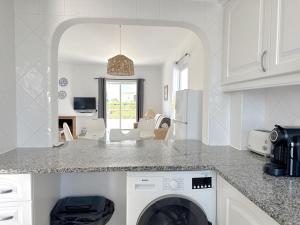 a kitchen with a washer and dryer in a room at Sunset Haven Algarve in Albufeira