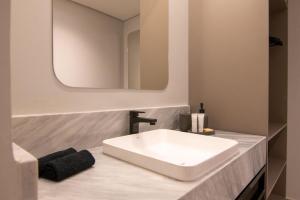 un bagno con lavandino bianco e specchio di Hotel Mandu a Teresina Altre 50 foto