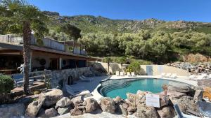 a house with a swimming pool and a resort at Hôtel Domaine A Flatta in Calenzana