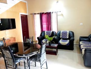 a living room with a table and a couch at Happy Stay in Vagamon